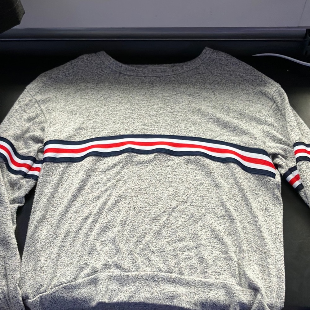 gray long sleeve shirt w/ blue, white, and red decal